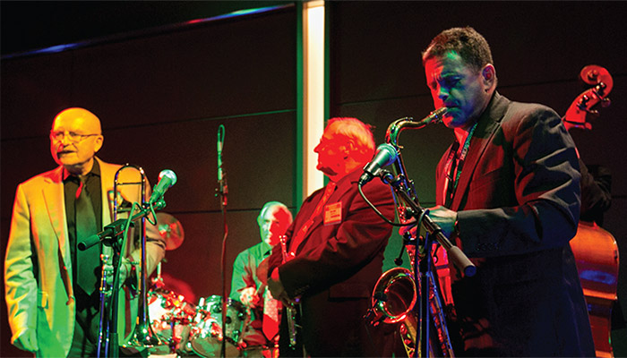 Band playing in low light, featuring saxophone player