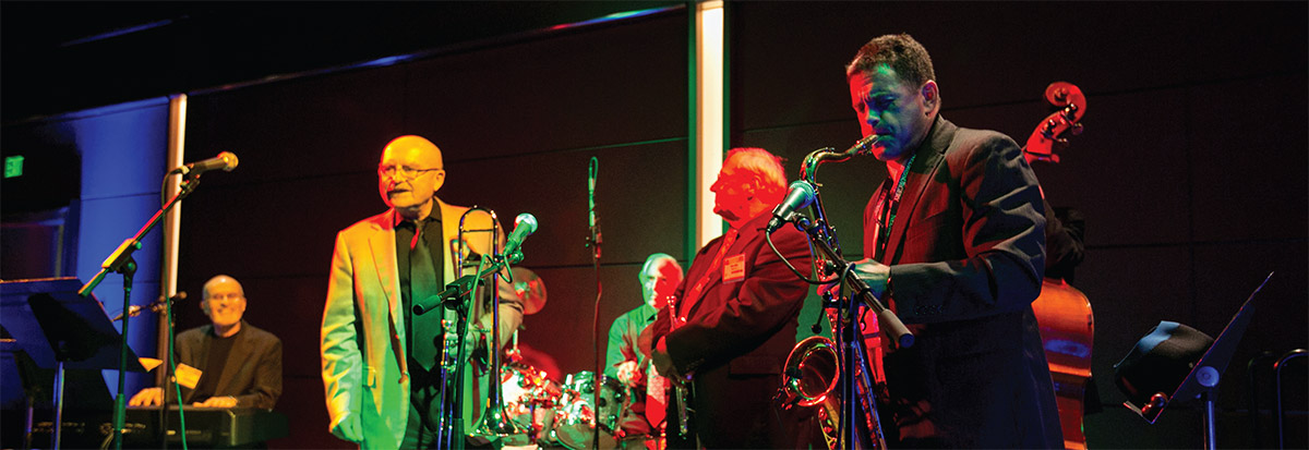 Band playing in low light, featuring saxophone player